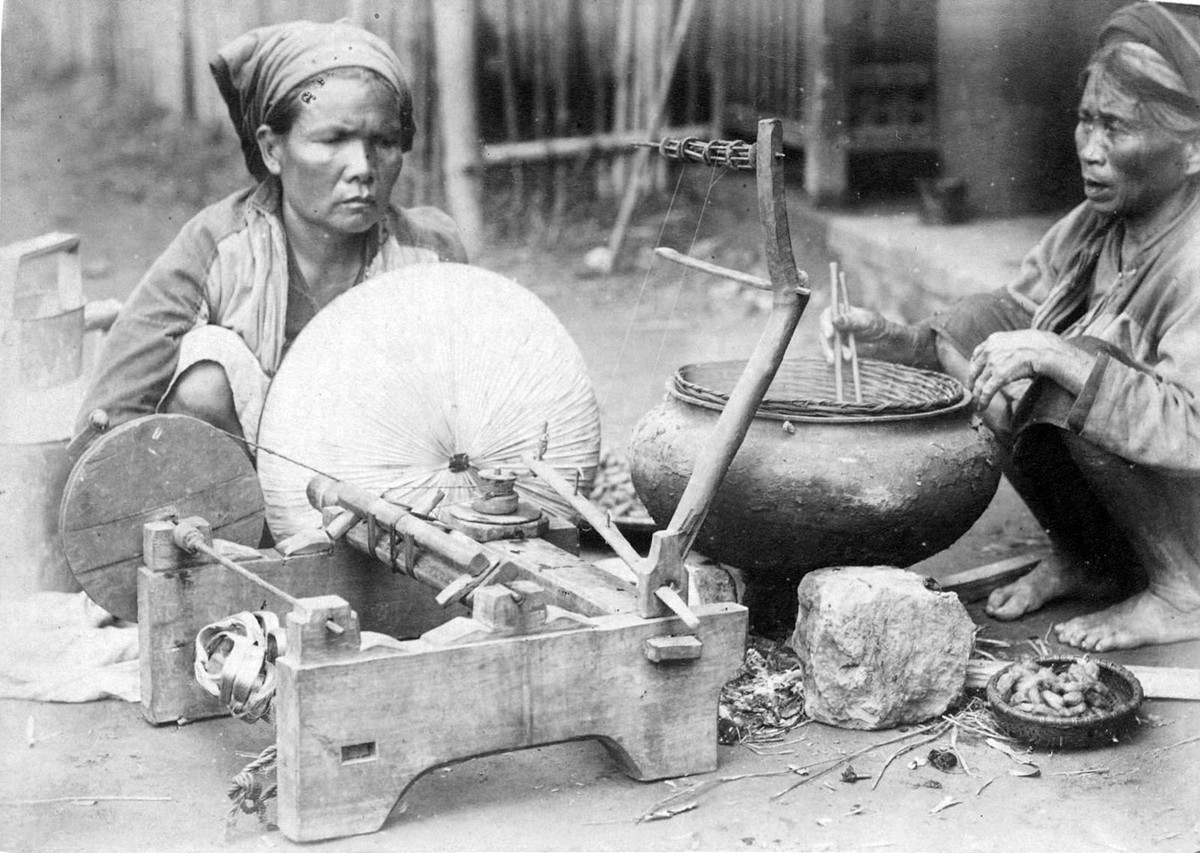 Hai phụ nữ cao tuổi kéo sợi tơ từ kén tằm được nấu chín, ngoại vi Hà Nội.