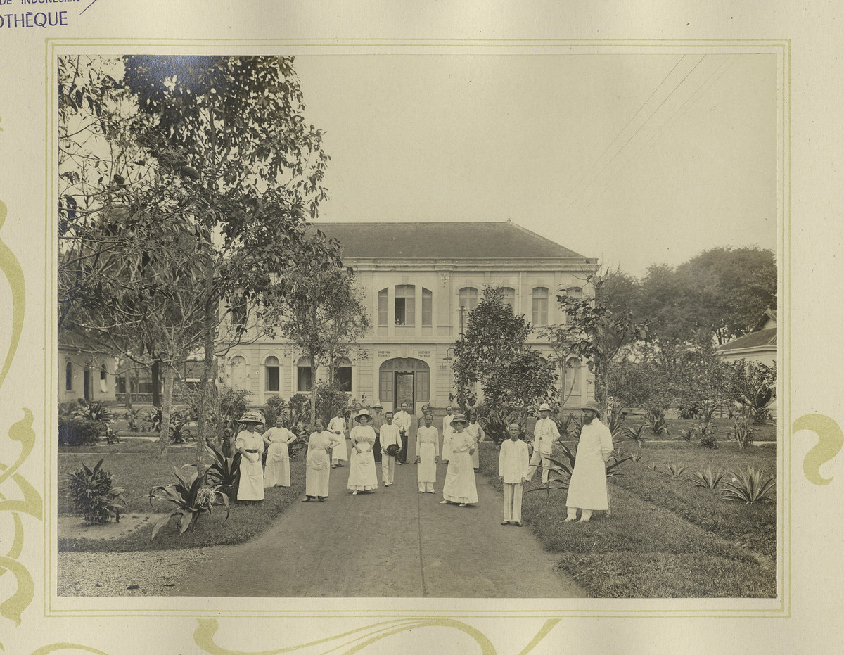 Các y bác sĩ, nhân viên bệnh viện Chợ Lớn đứng trước một tòa nhà của bệnh viện.