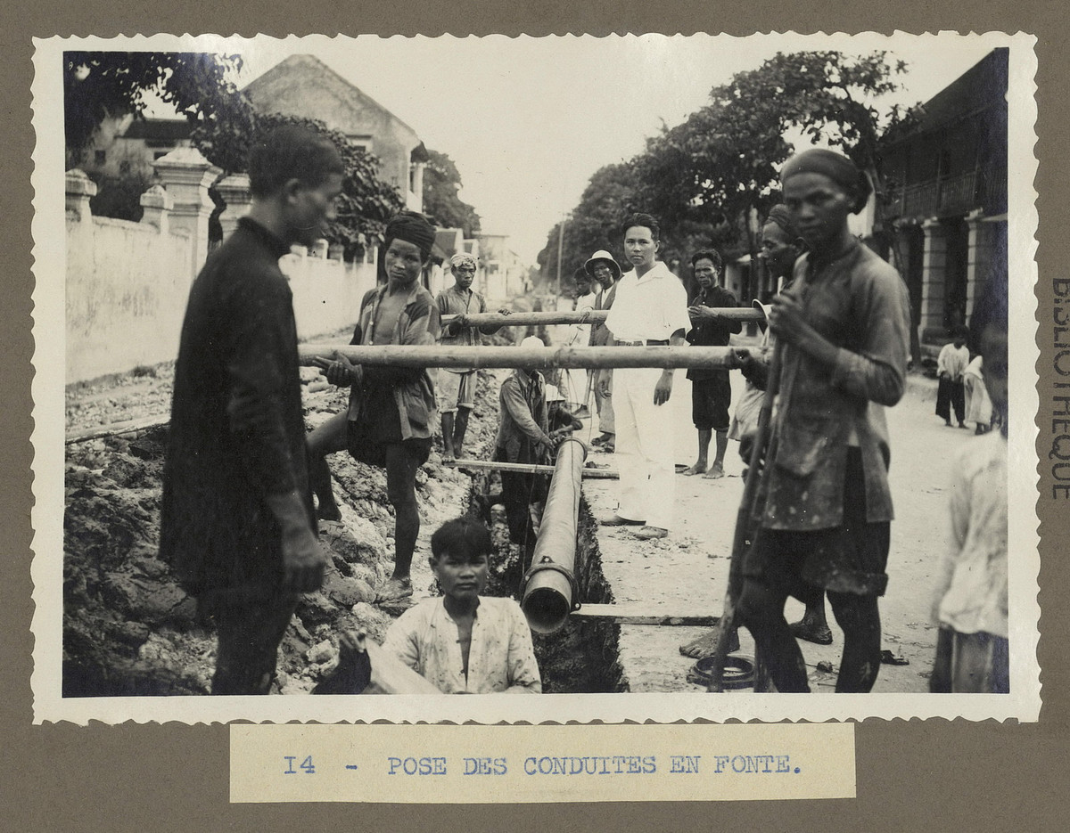 Công nhân người Việt một đoạn đường ống xuống rãnh.