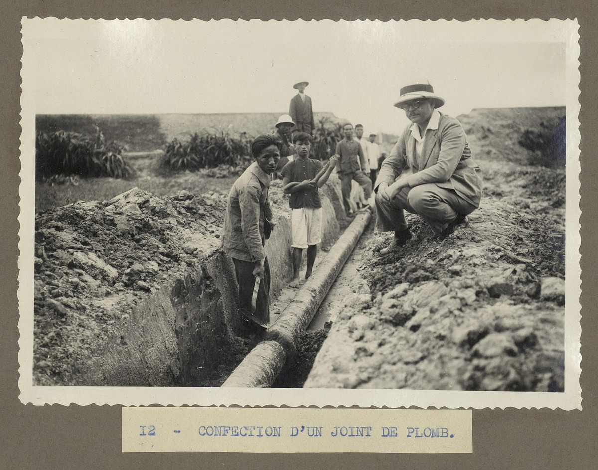 Công nhân lắp đặt con dấu chì trên một đường ống nước.