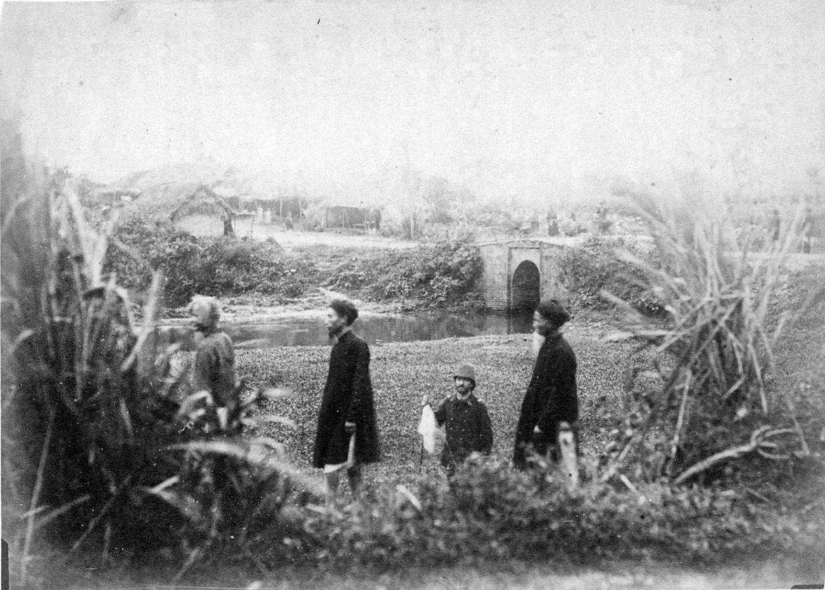 Người Pháp thăm lại nơi thi thể Francis Garnier từng được chôn cất trong ba ngày. Cây cầu phía xa là cầu Giấy, mang tên gọi như vậy vì cầu dẫn vào ngôi làng mà đa số người dân sống bằng nghề sản xuất giấy, theo ghi chú của người Pháp.