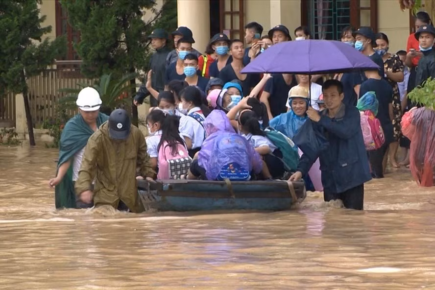 Lực lượng chức năng đưa thuyền vào tận cửa lớp đón học sinh. (Ảnh: Lao Động)