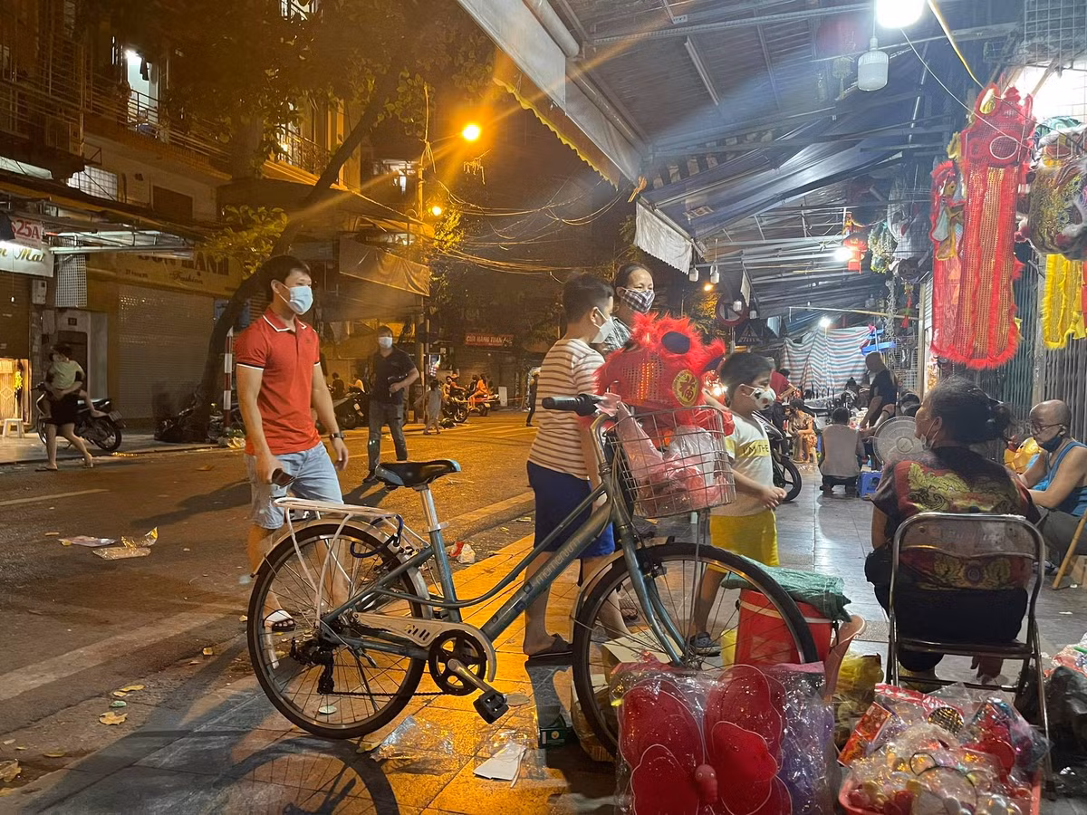 Người dân đưa con mình đi mua đồ trung thu nhưng vẫn đeo khẩu trang đầy đủ.