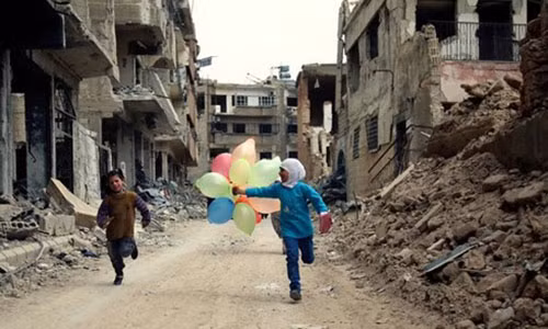 Những đứa trẻ chơi đùa giữa đống đổ nát ở Syria. (Ảnh: AP)