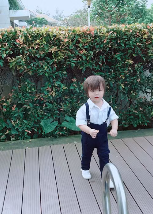 Con trai của Elly Trần diện trang phục cá tính, dạo chơi bên bể bơi.