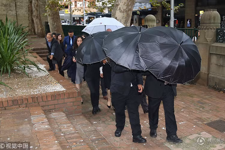 Đội vệ sĩ của Đổng Tuyền dùng ô che kín nữ diễn viên. Ảnh: QQ