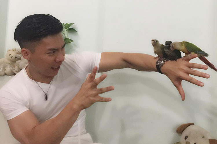 Hình ảnh Quốc Ngiệp diễn sâu làm ảo thuật với ba chú vẹt.