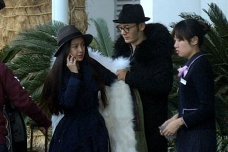 Huỳnh Hiểu Minh ân cần mặc áo cho Angelababy ở sân bay. Ảnh: QQ