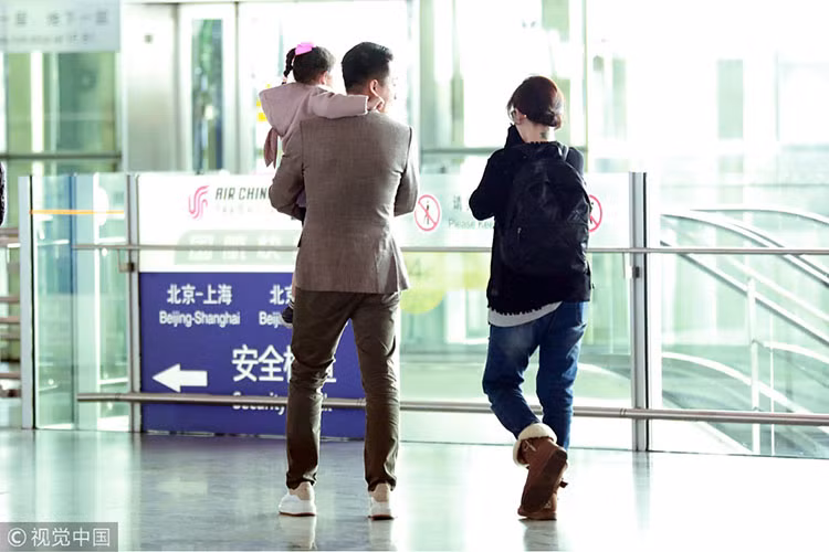 Đại S mặc áo rộng che vòng 2 đi bên cạnh ông xã bế con gái đầu lòng. Ảnh: 163