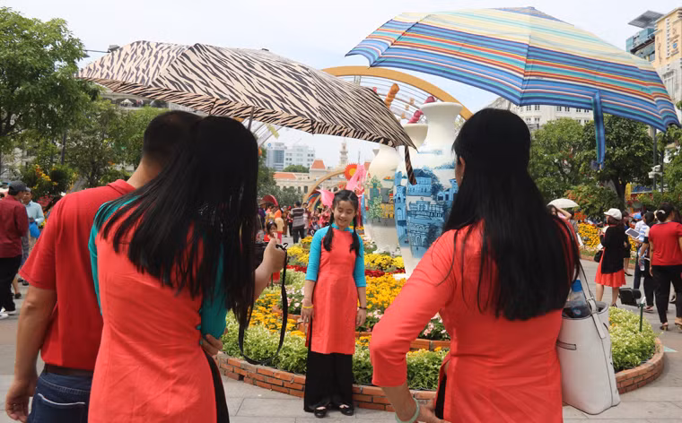 Muôn kiểu trốn nắng dạo đường hoa Nguyễn Huệ của du khách.