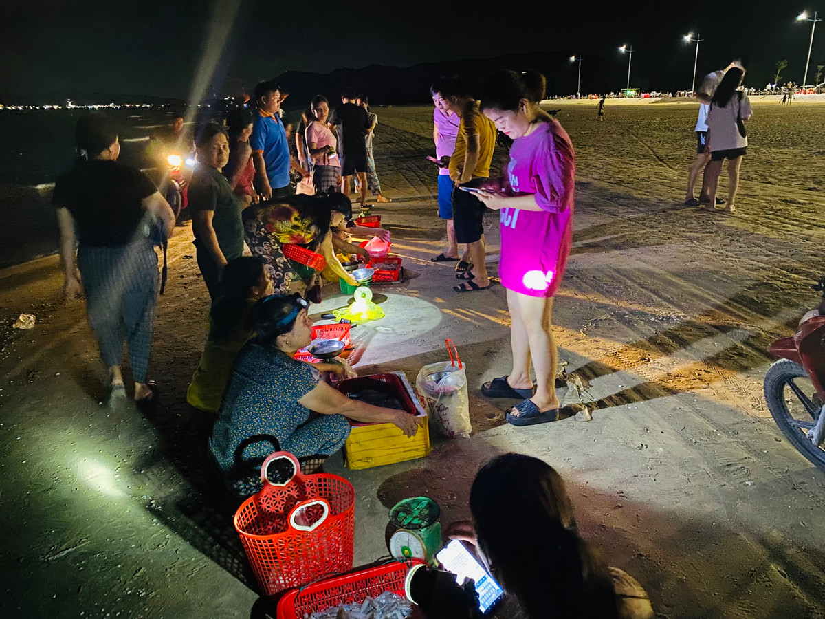 Mực tươi ngon, giá cả hợp lý khiến nhiều người dân kéo về bãi biển Kỳ Ninh để săn mực nháy cập bờ.