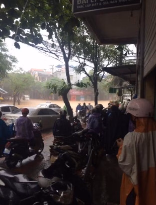 Do mưa lớn, đường ngập, nhiều người không thể đi lại.