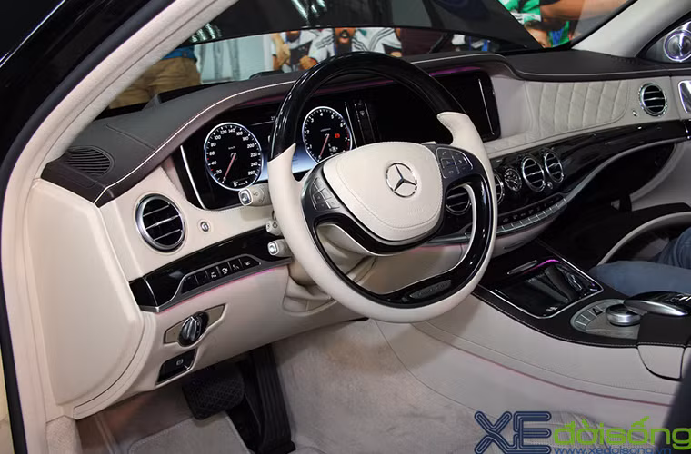 Tay lái đa chức năng 2 chấu bọc da ốp gỗ. Ở chính giữa bảng điều khiển là đồng hồ mang thương hiệu IWC.