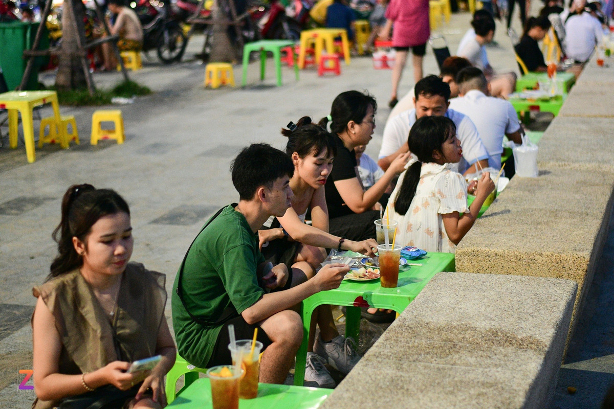 Dọc bờ kè biển Thương Chánh bày bán khá nhiều đồ ăn vặt, là điểm vui chơi của nhiều bạn trẻ. Kim Cúc (thứ 3 từ trái qua, sống tại TP.HCM) chia sẻ: "Chúng tôi dự định dành 3 ngày vui chơi ở đây. Trời khá nắng nên cả 2 dành nhiều thời gian ở nhà, chỉ tranh thủ ra đường để ngắm bình minh và hoàng hôn vào sáng sớm và chiều muộn".