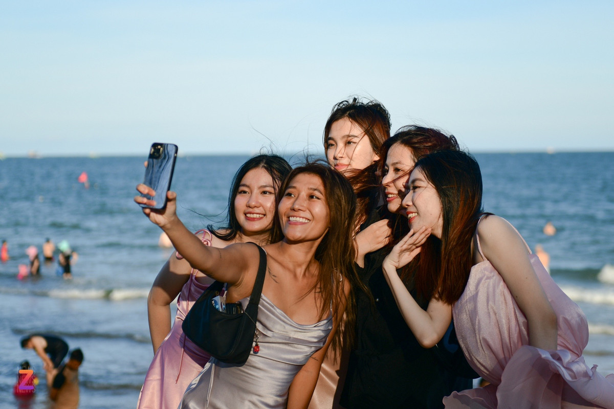 Đến Phan Thiết dự đám cưới, Ánh Linh (áo xám, sống tại TP.HCM) cũng tranh thủ ra biển chụp ảnh. "TP Phan Thiết rất đẹp, nhiều địa điểm du lịch nằm rải rác nên không quá đông đúc. Mặc dù buổi trưa nắng nóng nhưng cảm giác vẫn dễ chịu hơn TP.HCM nhờ có gió biển", Linh nói.