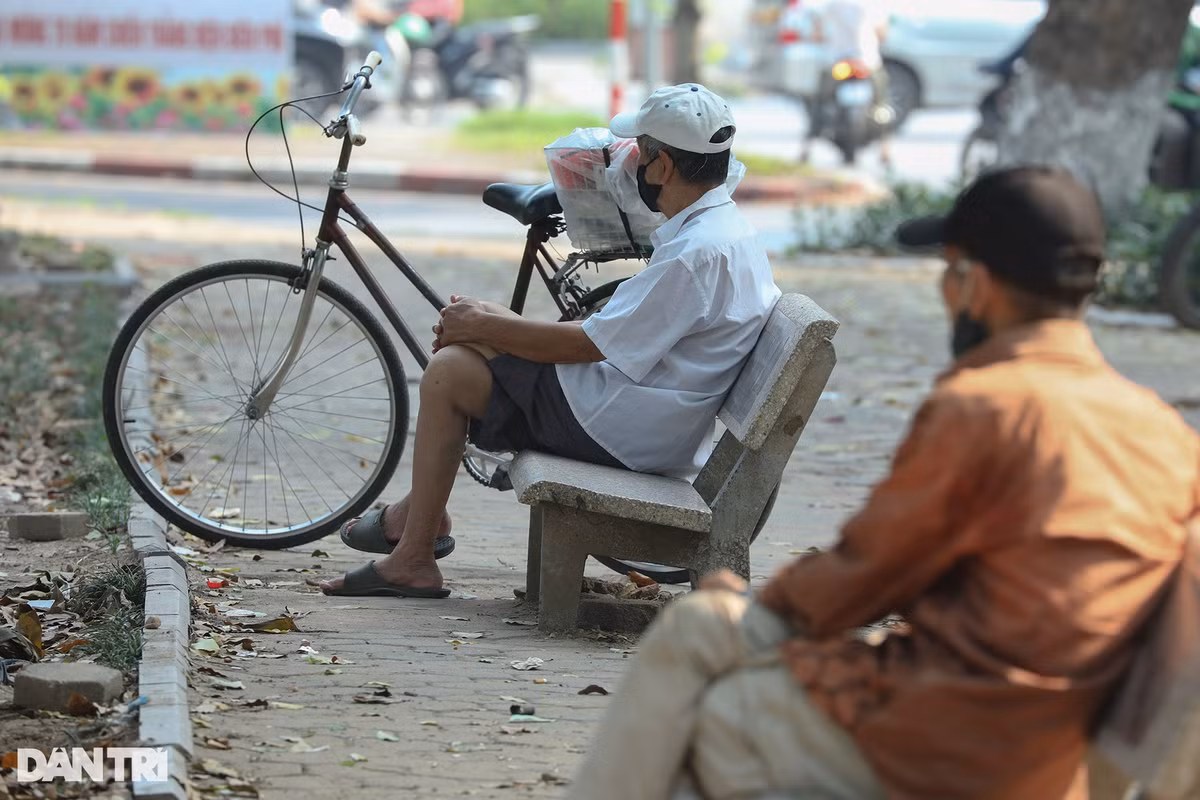 Số ít người dân thảnh thơi ngồi nghỉ trong bóng mát của hàng cây xanh ven hồ Thiền Quang. 