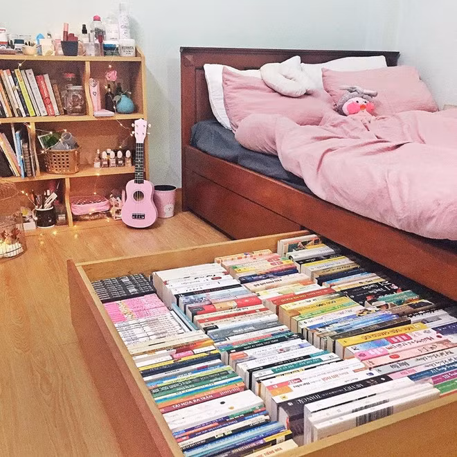 Bạn có mong có một góc nhỏ trong nhà đầy mơ mộng như thế này không? Nhìn qua gầm giường được thiết kế để chứa sách, chiếc đàn guitar và những đồ vật màu hồng, nhiều người đoán cô gái này chắc hẳn rất tài năng. Ảnh: Hồng Duyên.