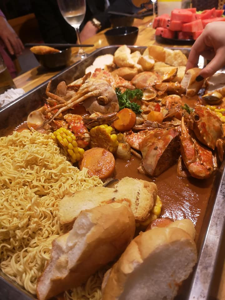 Bánh mì và mì tôm trần qua nước sôi là món ăn kèm của hải sản bốc tay này.