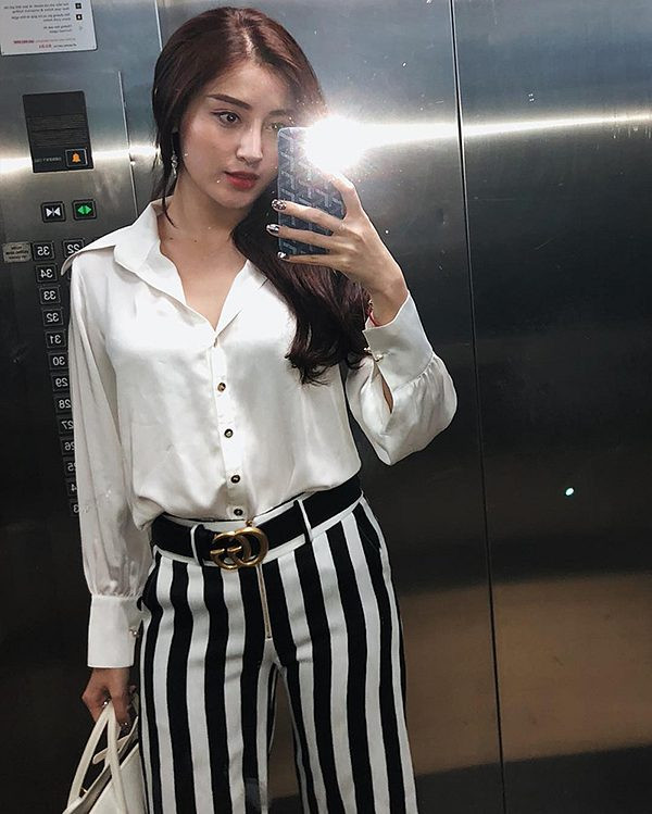 Huyền My chọn áo sơ mi cổ điển để kết hợp cùng quần kẻ sọc – mẫu trang phục được dự đoán sẽ tạo nên sức cuốn hút mới ở mùa hè năm nay.