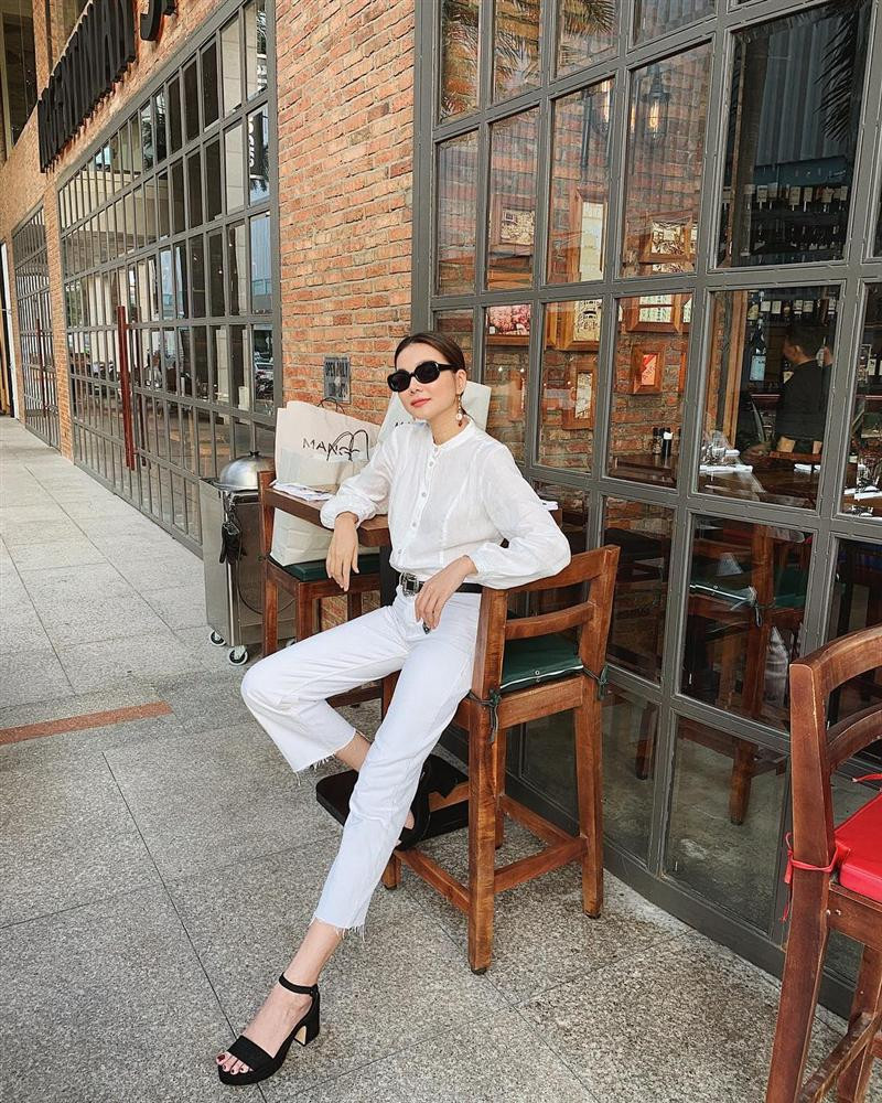 Sơ mi trắng là items quen thuộc mà bất cứ ai cũng sở hữu vài chiếc trong tủ đồ. Tưởng chừng nhàm chán nhưng Thanh Hằng lại có cách mix&amp;match vừa kín đáo mà không kém phần thu hút. Chân dài chọn sơ mi cổ trụ sơ vin quần ống lửng theo công thức all white, nhấn nhá bằng phụ kiện gam đen tinh tế.