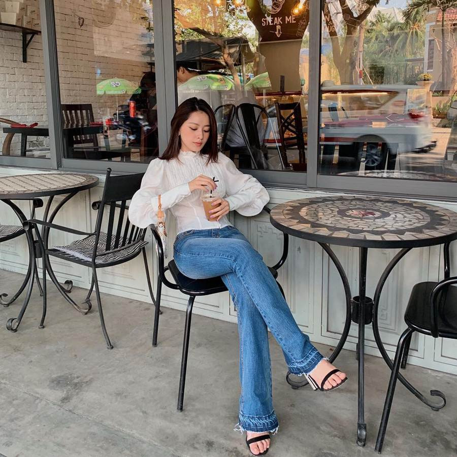 Chi Pu lăng xê chiếc áo sơ mi tay phồng có thiết kế chiết eo nhẹ nhàng, kết hợp quần jeans ống loe theo phong cách vintage.