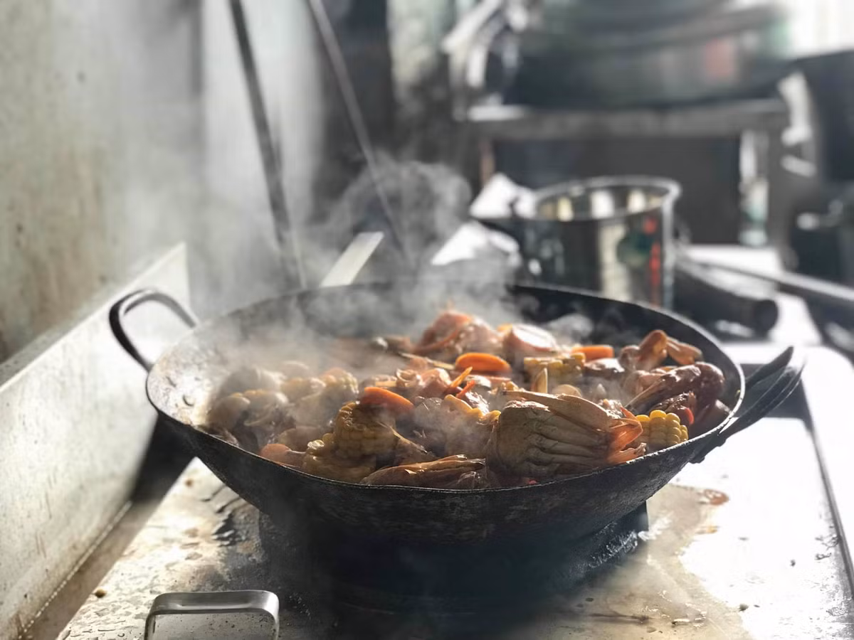 Hải sản kèm ngô, cà rốt và nước sốt sẽ được nấu chín trước khi cho ra xô.