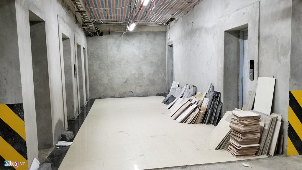 Dưới tầng hầm gửi xe, vật liệu xây dựng ngổn ngang, hệ thống thang máy chưa hoàn thiện. Cư dân ở đây cho biết họ bất bình mỗi khi gửi, lấy xe phải tiếp xúc với bụi, bẩn của vật liệu xây dựng.