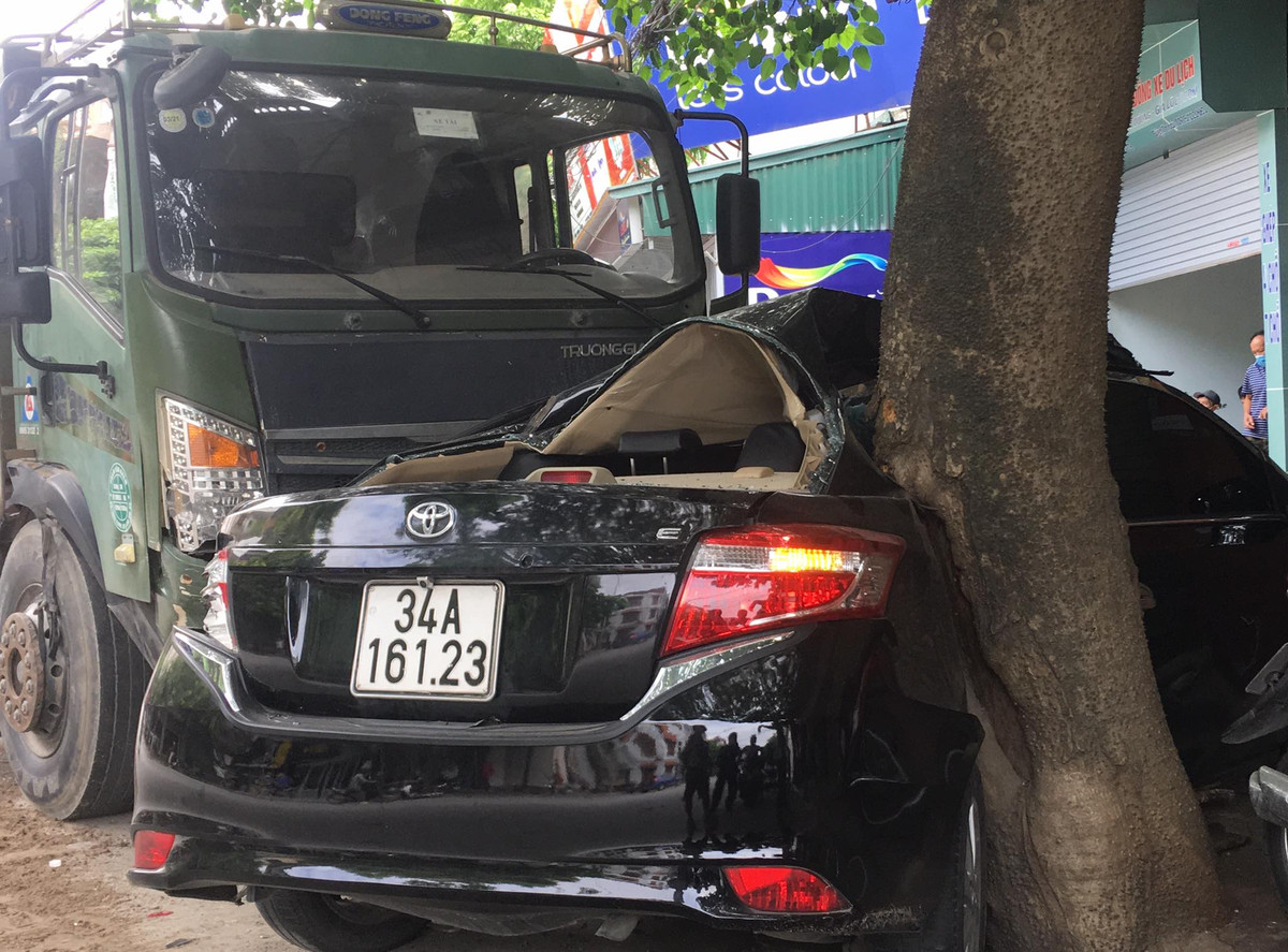 Xe con bị xe tải đâm đẩy vào gốc cây, hư hỏng nặng.