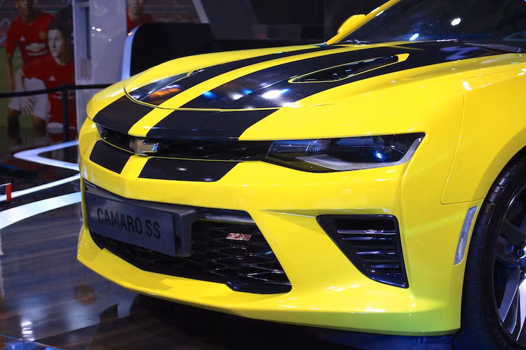 Trong đó, nổi bật nhất phải kể tới phần đầu trước cực "chiến" với cặp đèn pha LED nối liền với nhau bởi lưới tản nhiệt hẹp có logo Chevrolet ở chính giữa. Phiên bản Camaro SS này cũng có cản trước thể thao hơn với các khe hút gió kích thước lớn. Nhìn tổng thể, cụm đèn pha, lưới tản nhiệt và cản trước tạo thành hình một bộ mặt đầy dữ dằn đang "lườm" vào người chiêm ngưỡng.