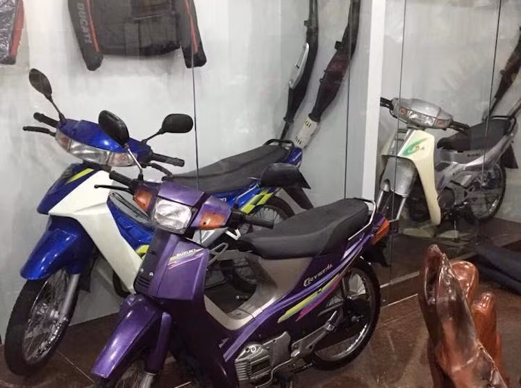 Bên cạnh tủ kính trưng bày chiếc RGV 120 là một số mẫu xe 2 kỳ nổi tiếng của Suzuki khác, chẳng hạn như chiếc RG Sports 110 đời đầu (màu bạc trong ảnh), RG Sports 110 đời cuối, RGX 120 2003...