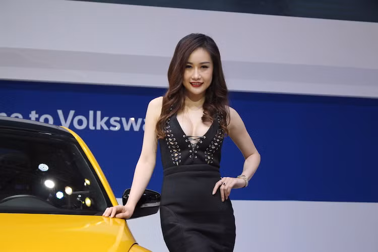 Người mẫu của thương hiệu Volkswagen trong bộ đầm màu đen tương phản với sắc vàng của chiếc "Beetle Dune" bên cạnh.