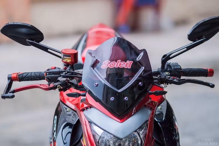 Ở phần đầu xe, phía trên đèn pha, chủ xe đã lắp cho GSX-S1000 chiếc kính chắn gió tối màu của Puig với thiết kế góc cạnh và cản gió tốt hơn. Hai bên là cặp gương chiếu hậu Rizoma Ellise với thiết kế hấp dẫn và tầm nhìn lớn hơn gương trên xe nguyên bản.