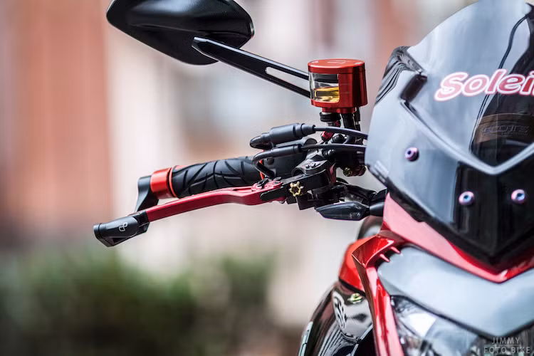 Trong khi đó, ở bên còn lại là sự xuất hiện của bình dầu Rizoma Next, cùm phanh Brembo, tay CRG Folding và vòng bảo vệ tay phanh Lightech.