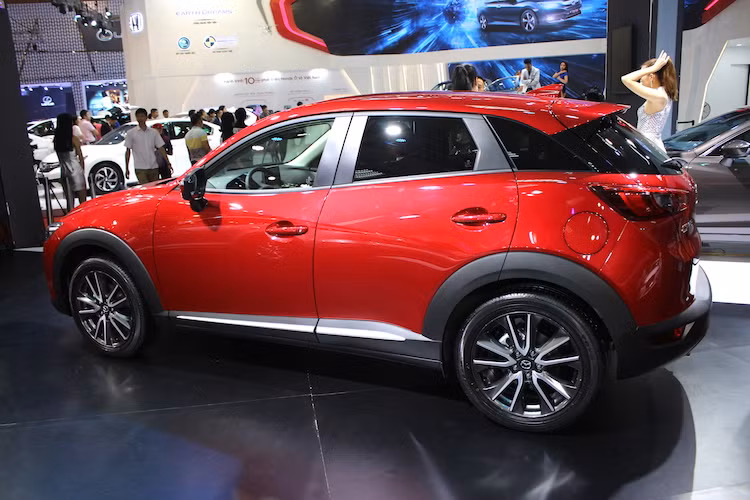 Giống như nhiều mẫu crossover khác, xung quanh thân xe của Mazda CX-3 được ốp nhựa đen khoẻ khoắn,vừa có tác dụng bảo vệ trước đất đá bắn lên từ mặt đường. Một chi tiết thiết kế rất độc đáo của xe là cột D được ốp một tấm nhựa đen bóng tiệp màu với kính, tạo cảm giác mui đang "nổi" trên thân xe.