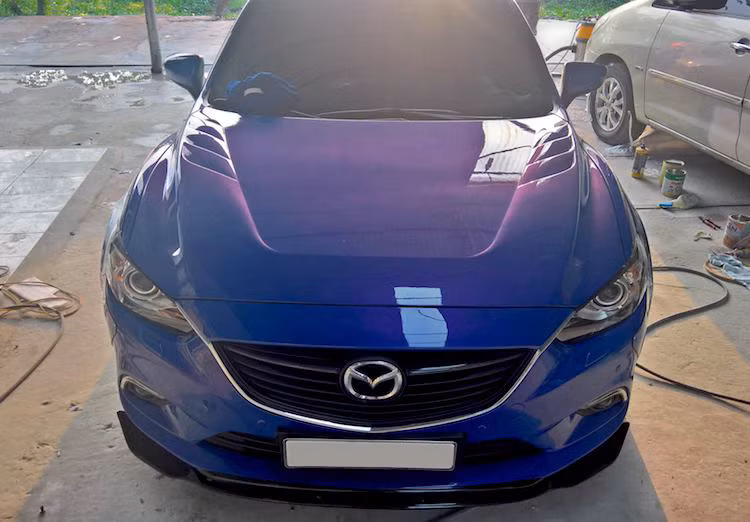 Ở phía trước, QS Performance đã giữ nguyên cản nguyên bản của Mazda 6. Tuy nhiên ở bên dưới cản, một cánh khuếch tán không khí đã được lắp cho chiếc xe. Trong khi đó, ở phía trên nắp ca-pô đã được dập nổi các đường gân và khe tản nhiệt mới đầy thể thao.