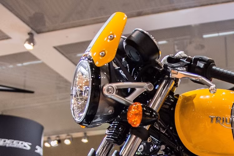 Ở phía trước, Street Cup vẫn giữ nguyên cụm đèn pha và đèn xi-nhan từ Street Twin. Tuy nhiên ở ngay phía trên, Triumph đã bổ sung cho chiếc xe một chiếc "mào" chắn gió cổ điển, đồng thời màu chóa và vành đèn pha được sơn ngược lại so với Street Twin.