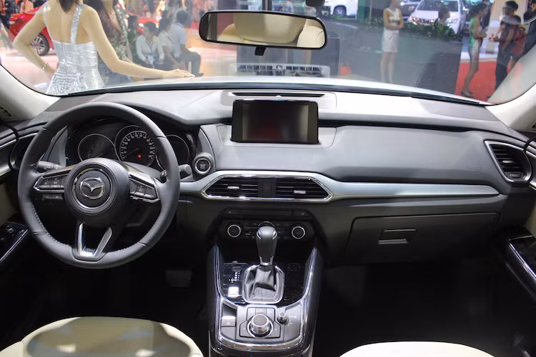 Cũng giống như các dòng xe mới của Mazda, nội thất của CX-9 được thiết kế theo phong cách tối giản, hướng tới người lái. Trên bảng táp-lô là hệ thống thông tin giải trí Mazda Connect thế hệ mới với màn hình cảm ứng 7 inch. Cụm nút điều chỉnh hệ thống điều hòa của CX-9 được đặt sâu xuống phần dưới bảng táp-lô.