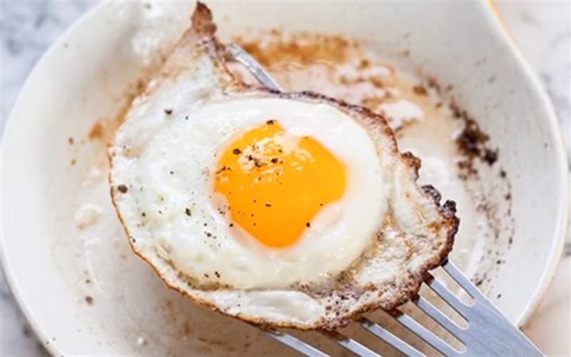 Ăn trứng ốp la vừa giúp bạn no lâu, vừa giúp đốt cháy mỡ mặt, lại vừa cung cấp cho cơ thể rất nhiều chất dinh dưỡng như vitamin B12, B6, D, A, E và K, choline, folate, lutein, sắt, canxi, kẽm, phốt pho và chất béo omega-3. Ảnh: cooky.