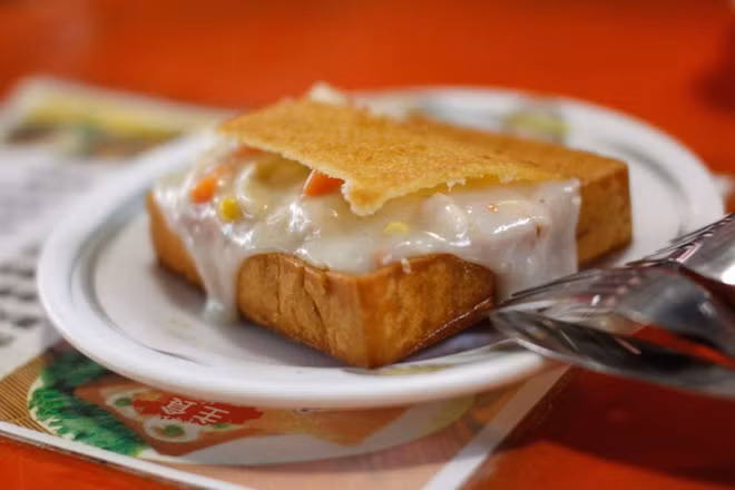 Thực chất, bánh mì quan tài chỉ là một lát bánh mì nướng giòn có độ dày khoảng 3 - 4cm, được khoét rỗng ở giữa và có nắp đậy phía trên. Ảnh: traveltimes.