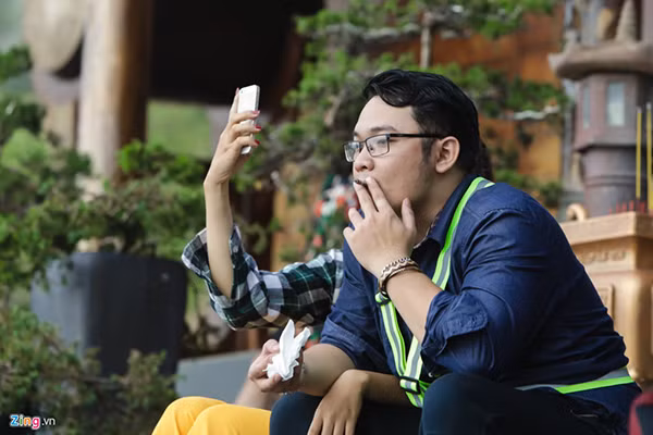 Thanh niên hút thuốc khi ngồi trước tượng Phật ở Quán Chiếu Đường.