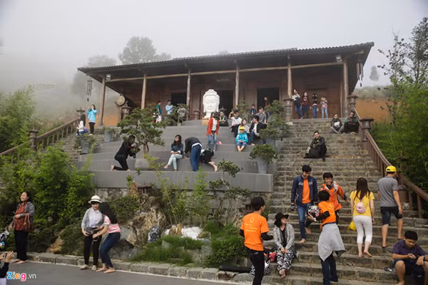 Các bạn trẻ đứng ngồi chờ mây mù tan để ngắm biển mây.