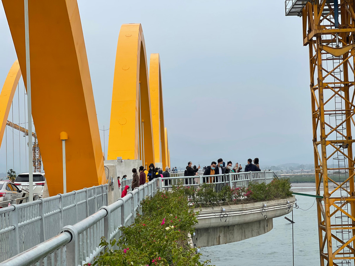 Người dân đỗ xe dọc cây cầu để tranh thủ chụp bức ảnh “check in” đầu năm mới tại cầu Tình Yêu.