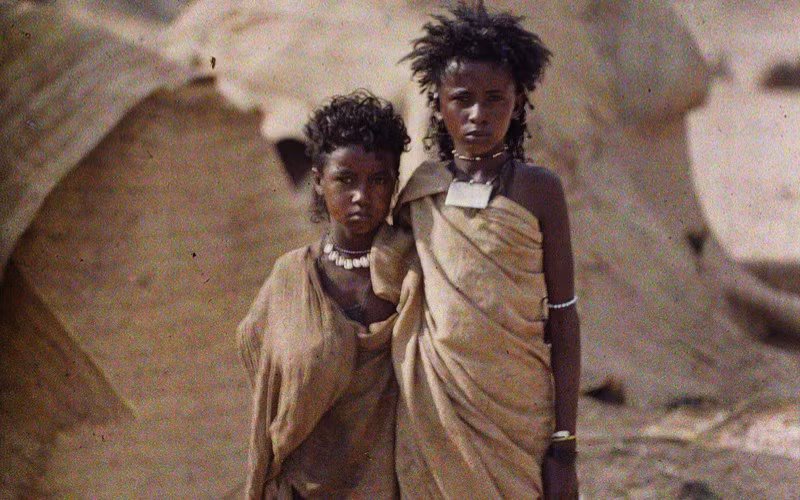 Hai thiếu nữ bộ tộc Bishari đứng trước căn lều dựng theo kiểu truyền thống, Ai Cập năm 1914. Ảnh: Albert Kahn.