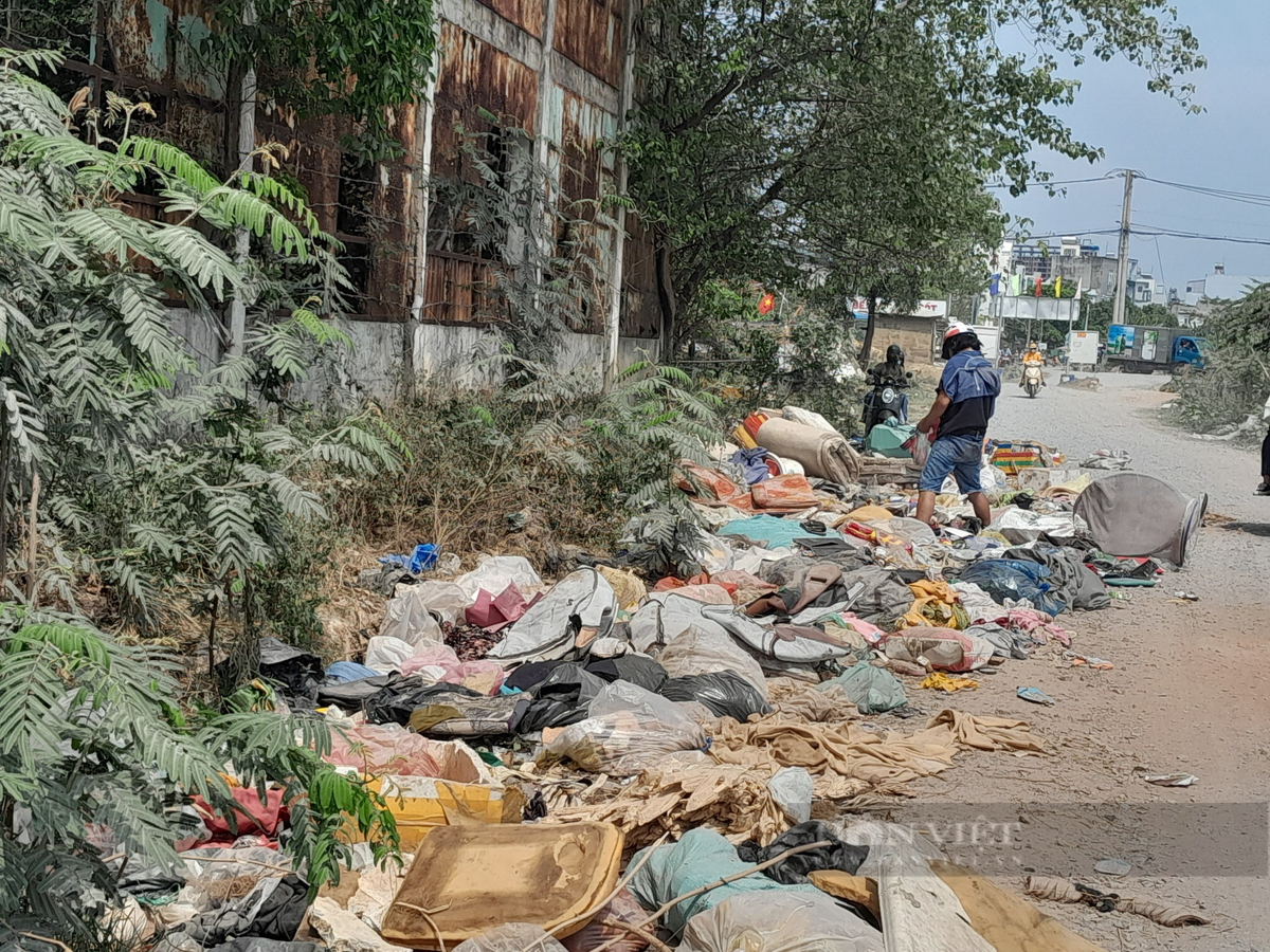 Trước thời điểm khởi công, người dân sống ven khu vực kênh Tham Lương phải di chuyển trên những con đường trải đá tạm, hai bên chứa đầy rác thải. (Ảnh: Dân Việt).
