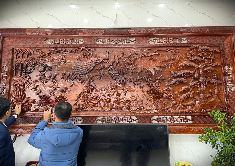 Bức tranh gỗ “bách điểu hoan ca” của nghệ nhân Đinh Xuân Đồng (SN 1964, thuộc hệ thống Danh Gia Vọng Tộc, ở Bắc Ninh) được chế tác nên từ gỗ Hương nguyên khối dài 3,7m; rộng 1,6m; dày 10cm.