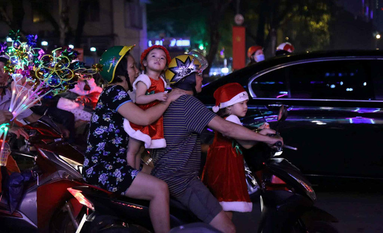 Nhiều em nhỏ được ông bà, bố mẹ đưa đi vui chơi trong đêm Noel.