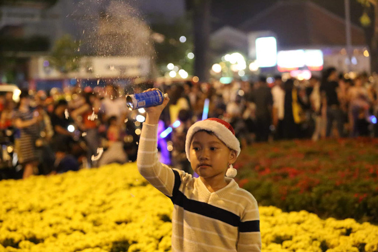 Một em nhỏ tỏ ra thích thú với bình tạo "tuyết".