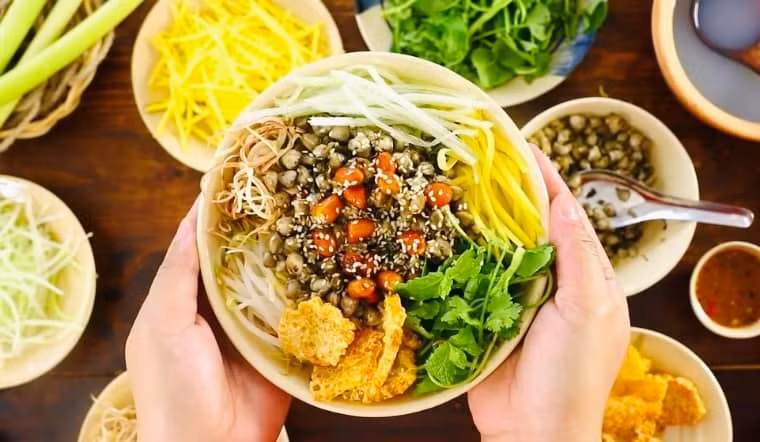 Ẩm thực Huế không thể không nhắc đến cơm hến, một trong những món ăn ngon Huế kết hợp hoàn hảo từ các hương vị tạo nên một món ăn độc đáo, lạ miệng nhưng cũng được thực khách rất ưa chuộng. Món ăn là sự hòa trộn hài hòa cả về màu sắc lẫn hương vị, một chút sự cay nồng của gừng, cay của ớt, thơm của rau và vị ngọt của hến vị bùi của lạc. Ảnh Internet