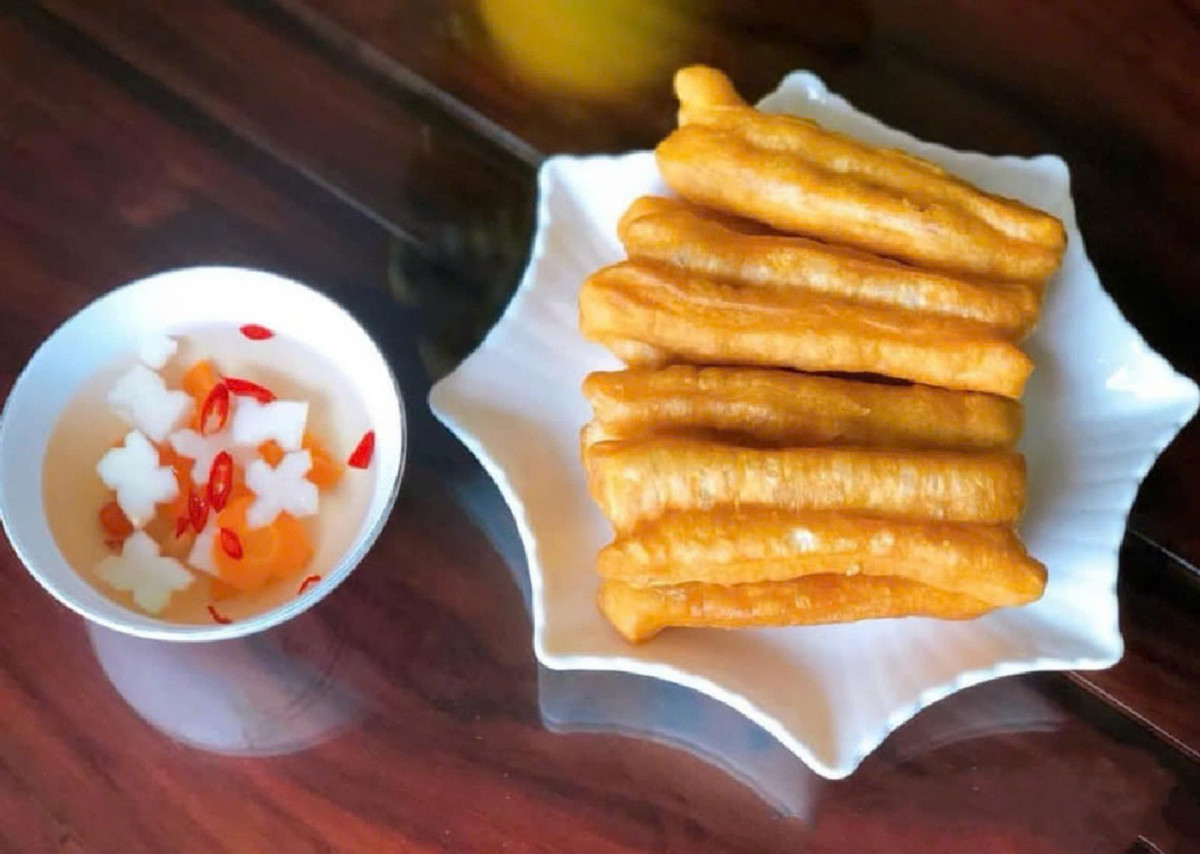 Quẩy nóng thường được coi là món ăn ngày trở gió, phổ biến ở các quán ăn vỉa hè tại Hà Nội. Quẩy được làm từ bột mì, trứng, muối, bột nở. Bột được nhào trộn rồi ủ, sau đó chia thành từng miếng vừa ăn. Khi khách tới mua, chủ hàng mới thả những dải bột vào chảo ngập dầu đang sôi và rán vàng giòn. Quẩy nóng chấm với nước mắm chua ngọt, ăn kèm dưa góp đu đủ, cà rốt. Ảnh Internet