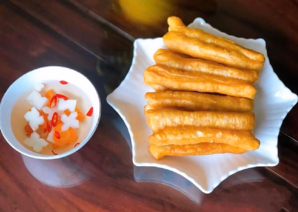 Quẩy nóng thường được coi là món ăn ngày trở gió, phổ biến ở các quán ăn vỉa hè tại Hà Nội. Quẩy được làm từ bột mì, trứng, muối, bột nở. Bột được nhào trộn rồi ủ, sau đó chia thành từng miếng vừa ăn. Khi khách tới mua, chủ hàng mới thả những dải bột vào chảo ngập dầu đang sôi và rán vàng giòn. Quẩy nóng chấm với nước mắm chua ngọt, ăn kèm dưa góp đu đủ, cà rốt. Ảnh Internet